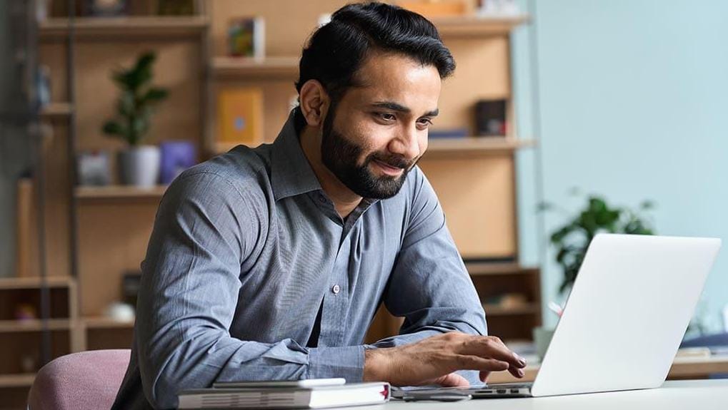 Young businessman taking a certification exam on his laptop