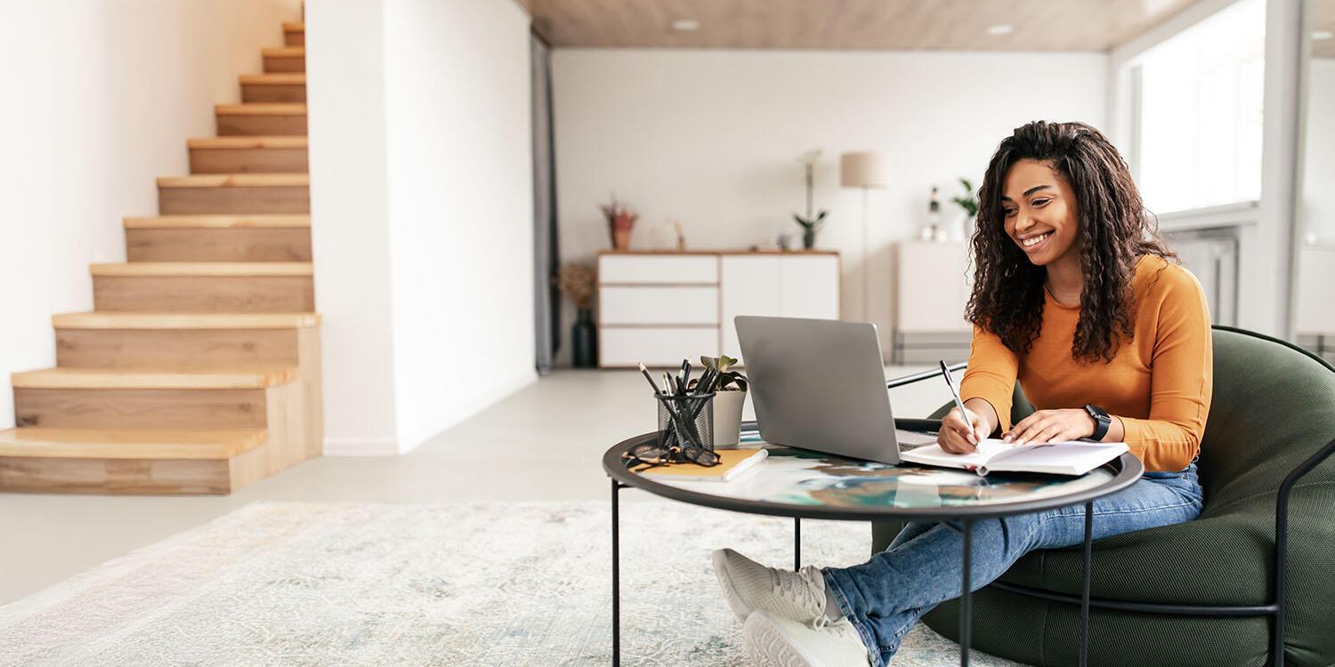 Young woman working on laptop with notebook